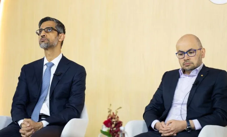 Sundar Pichai and another man sit on stage at a conference.