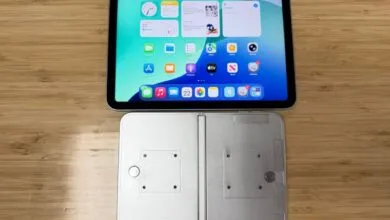 Foldable iPhone prototype with iPad on a wooden table.