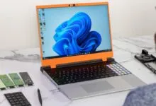 Framework Laptop 16 with customizable modules on a marble surface.