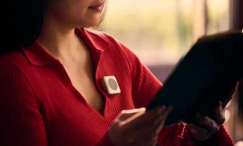Woman in red sweater with wearable device reading a book.
