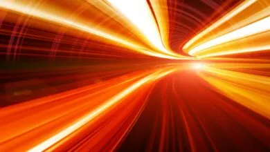 Abstract image of blurred orange and yellow light streaks in a tunnel.