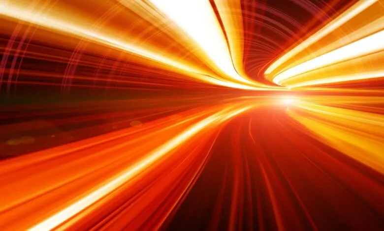 Abstract image of blurred orange and yellow light streaks in a tunnel.