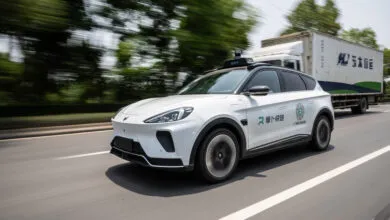 Baidu Apollo RT6 robotaxi driving on a road with motion blur.