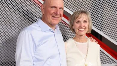 Steve Ballmer and his wife pose in front of a modern backdrop.