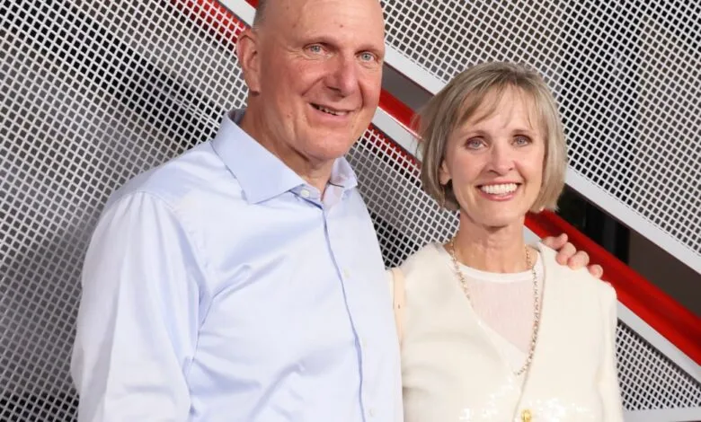 Steve Ballmer and his wife pose in front of a modern backdrop.