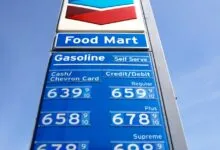 Chevron gas station sign showing high gasoline prices against a blue sky.