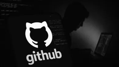 GitHub logo on phone screen with hacker silhouette in background.