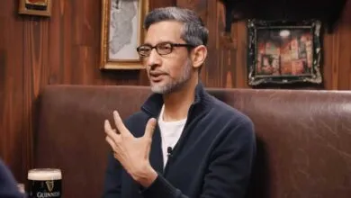 Sundar Pichai, Google CEO, gestures while seated in a pub-like setting.