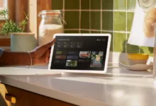 Google Nest Hub Max on kitchen counter, controlled by a person.