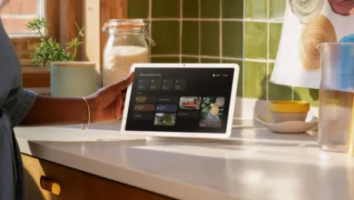 Google Nest Hub Max on kitchen counter, controlled by a person.