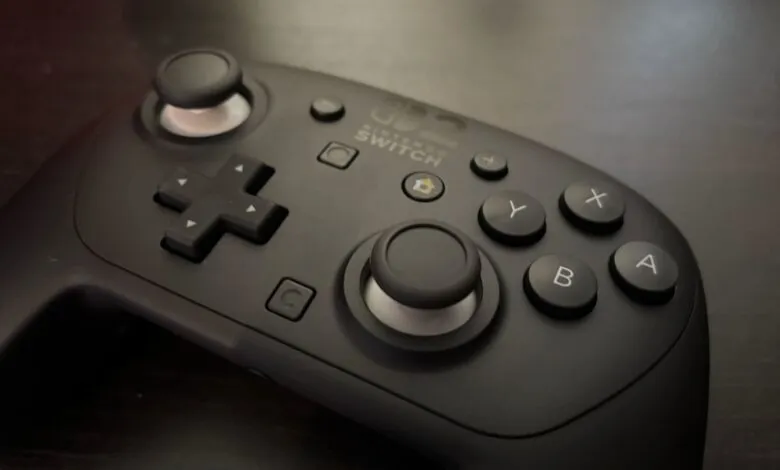 Close-up of a black Nintendo Switch Pro Controller on a dark surface.