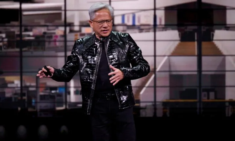 Jensen Huang presents in black jacket on stage with blurred background.