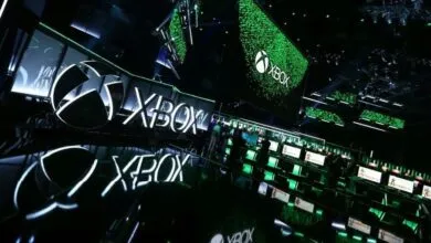 Xbox logo and gaming stations at a conference, showcasing the brand.
