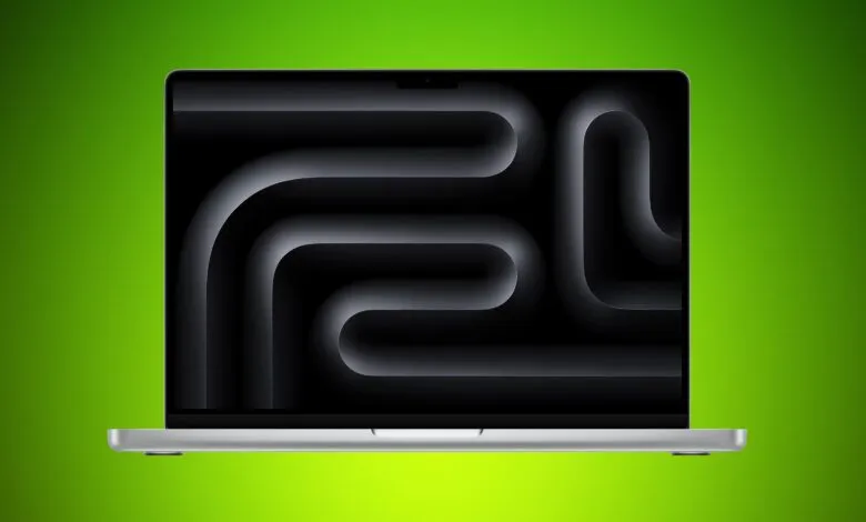 Silver MacBook Pro laptop with black abstract wallpaper on a green background.