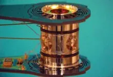 Close-up of a cylindrical metallic device with intricate wiring and circuit board elements.