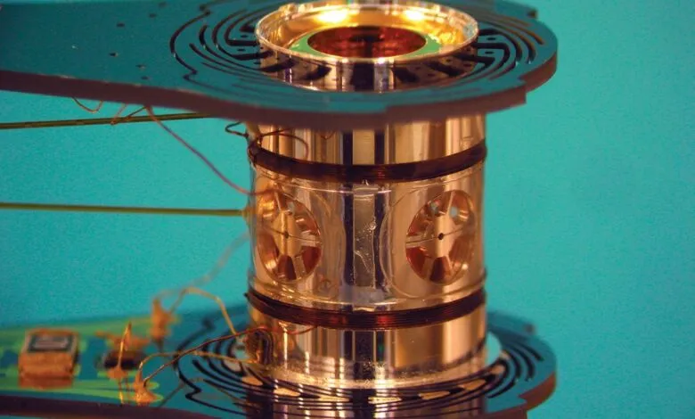 Close-up of a cylindrical metallic device with intricate wiring and circuit board elements.