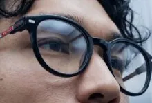 Close-up of a person wearing Nimo smart glasses with black frames.