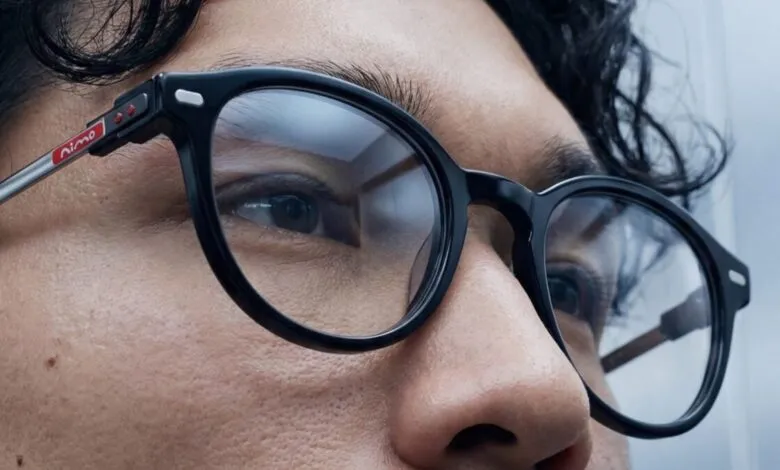 Close-up of a person wearing Nimo smart glasses with black frames.