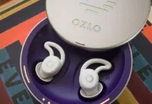 Ozlo sleep earbuds in charging case on colorful surface.