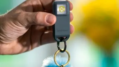 Hand holds Pebblebee Halo 2 key finder with light and keychain.