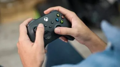 Hands holding a black Xbox controller, ready to play a game.