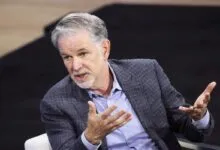 Reed Hastings gestures during a discussion, wearing a blue blazer.