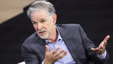 Reed Hastings gestures during a discussion, wearing a blue blazer.