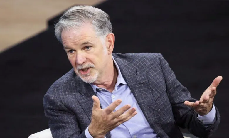 Reed Hastings gestures during a discussion, wearing a blue blazer.