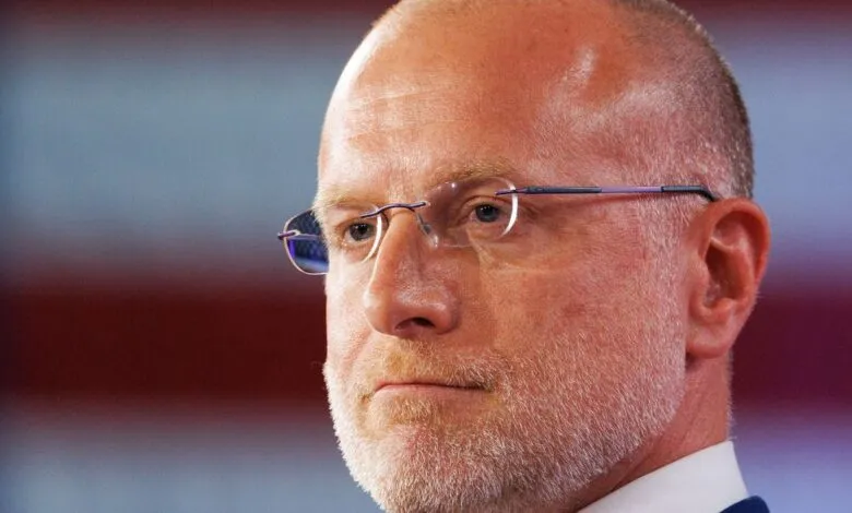 Close-up of Brendan Carr with glasses against blurred background.