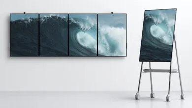 Surface Hub 2S displays a wave image across multiple screens, one on a mobile stand.