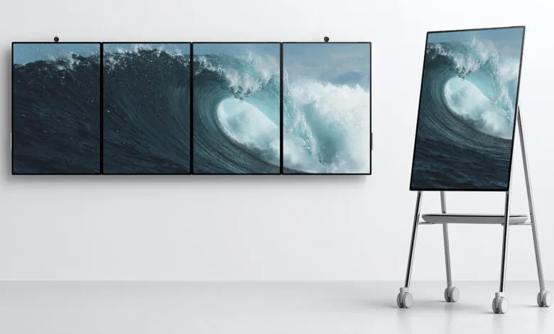 Surface Hub 2S displays a wave image across multiple screens, one on a mobile stand.