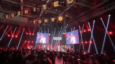 Audience watches Koike Yuriko, Governor of Tokyo, on stage at event.