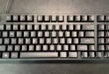 Black mechanical keyboard with red lettering on a dark surface.