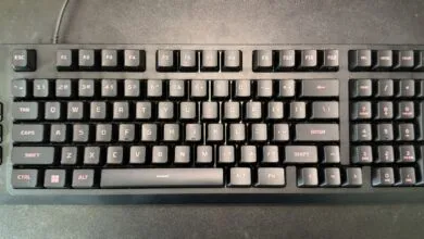 Black mechanical keyboard with red lettering on a dark surface.