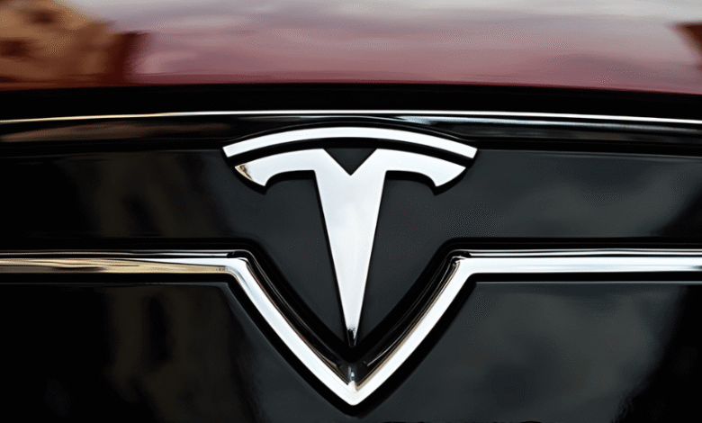 Close-up of the Tesla logo on a car's hood.