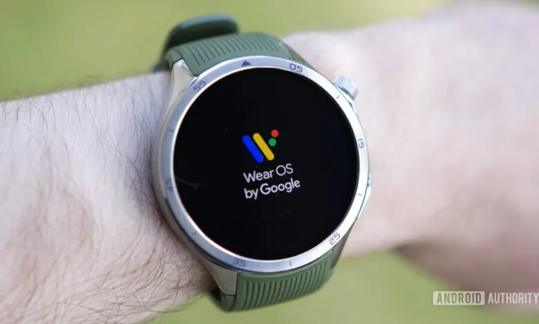 Wear OS smartwatch on wrist displaying the Wear OS by Google logo.