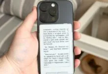 Hand holding iPhone with e-reader case displaying Sherlock Holmes excerpt.