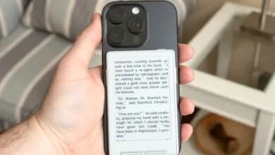 Hand holding iPhone with e-reader case displaying Sherlock Holmes excerpt.