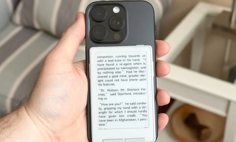 Hand holding iPhone with e-reader case displaying Sherlock Holmes excerpt.