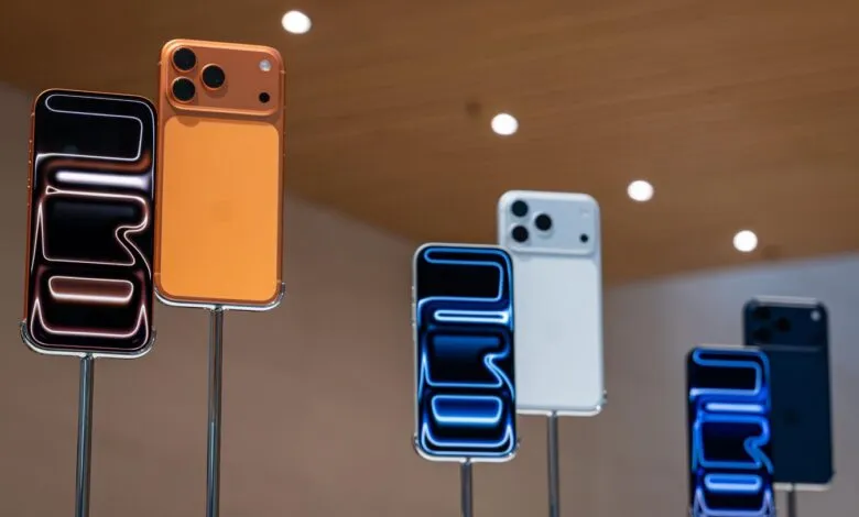 Display of various iPhone models in different colors on metal stands.