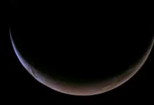 Crescent Mars glows against the blackness of space, showing atmospheric details.