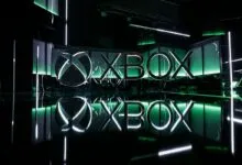 Illuminated Xbox logo with green accents and reflective surface.
