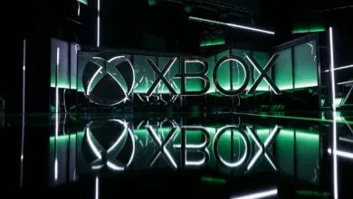 Illuminated Xbox logo with green accents and reflective surface.