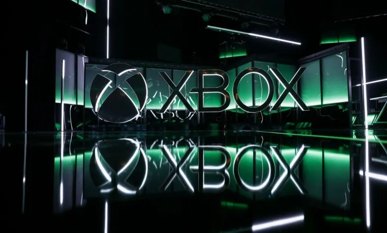 Illuminated Xbox logo with green accents and reflective surface.