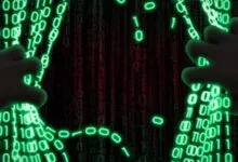 Hands pull apart a curtain of green binary code revealing a red binary background.