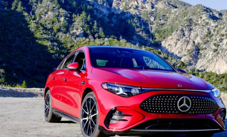 Red Mercedes CLA 350 parked on a road with a mountain backdrop.