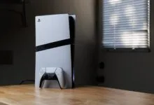 PlayStation 5 console and controller on a wooden surface.
