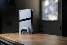 PlayStation 5 console and controller on a wooden countertop.