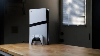 PlayStation 5 console and controller on a wooden countertop.