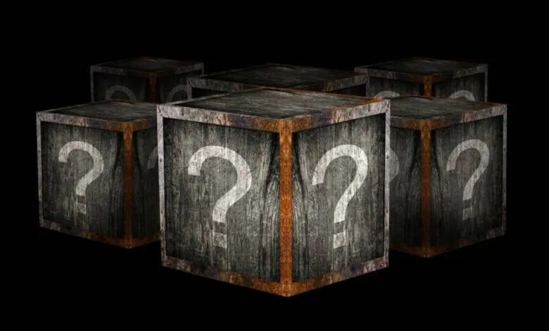 Six wooden crates with question marks on a black background.